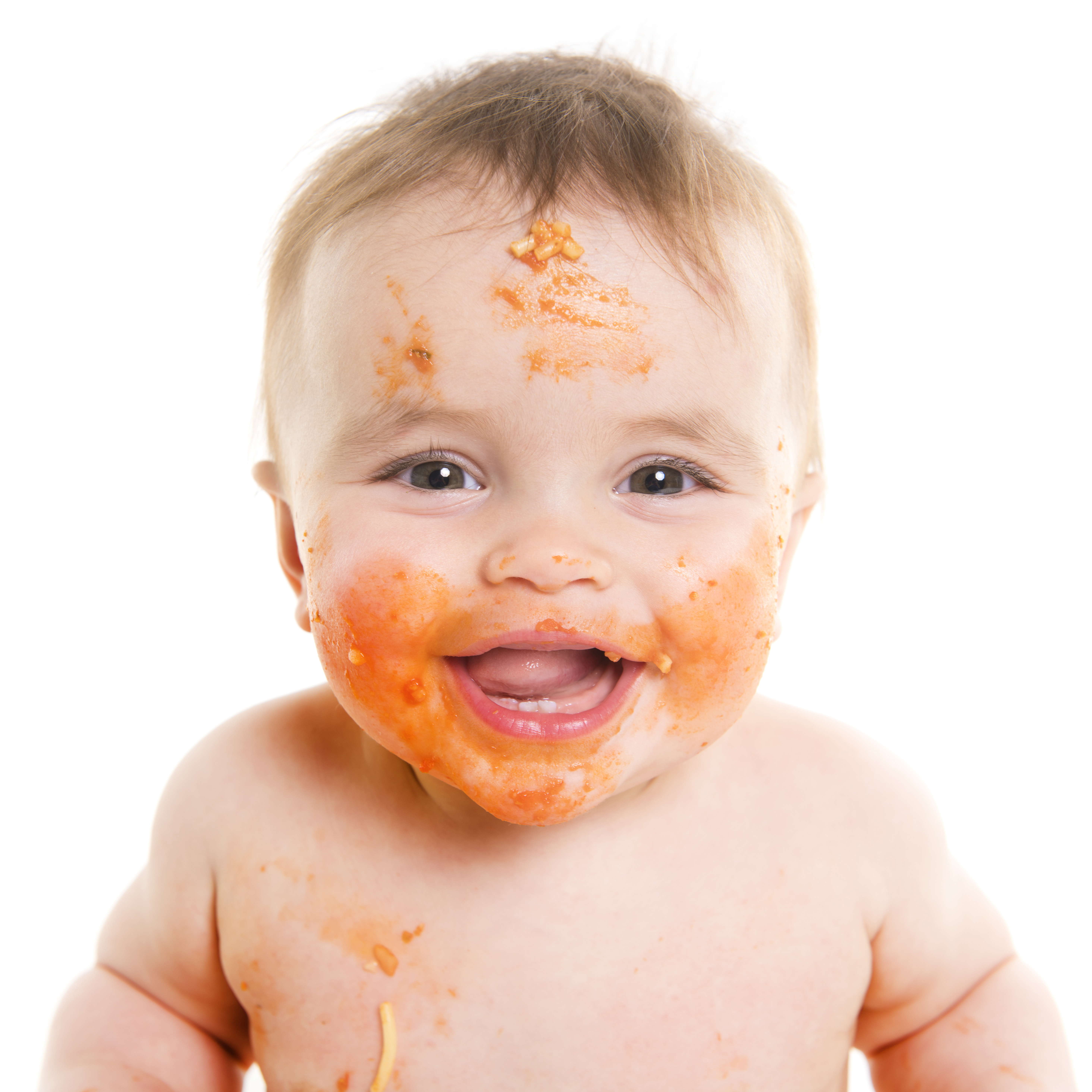 Messy, happy baby eating spaghetti